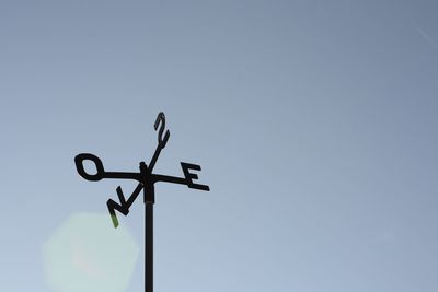 Low angle view of weather vane against clear sky