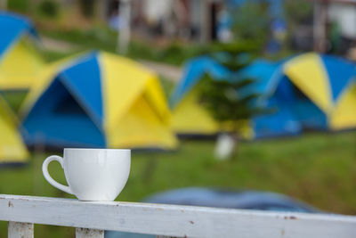 Close-up of cup on railing at campsite