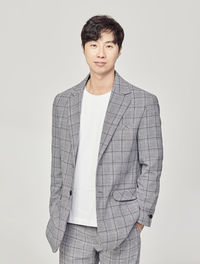 Portrait of young man standing against white background