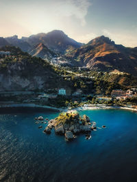 Aerial view of lake by rocks against sky