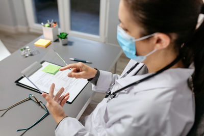Female doctor working with transparent tablet in office