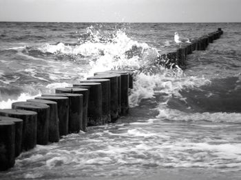 Waves splashing on sea against sky