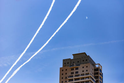 Low angle view of vapor trail against blue sky