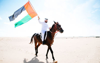 Man riding horse on beach