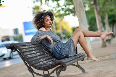 Thoughtful young woman looking away while sitting on bench