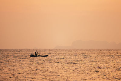 Silhouette boat in sea against sky during sunset