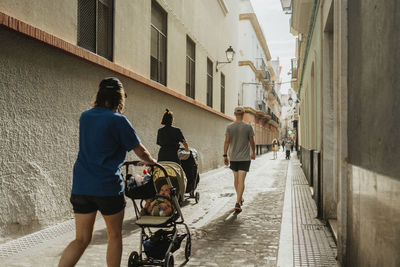 Parents with babies in strollers walking in city