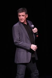 Portrait of man standing against black background