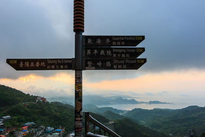 Information sign on mountain against sky