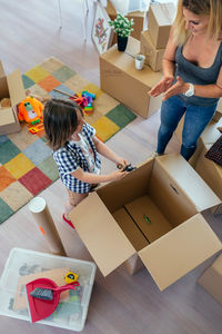 High angle view of mother with son unpacking boxes at home