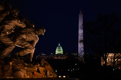 Statue of illuminated historic building at night