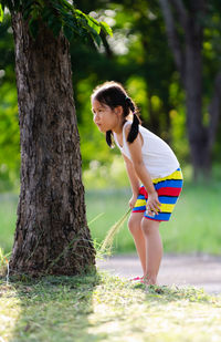 Girl standing by tree