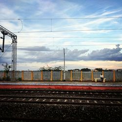 Railroad track against cloudy sky