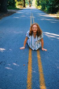 Portrait of a smiling young woman standing on road