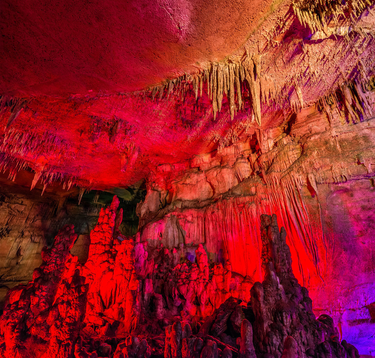 LOW ANGLE VIEW OF RED ROCK FORMATIONS IN CAVE