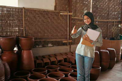 Full length of young woman standing against wall