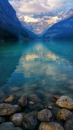 Scenic view of lake by mountains against sky