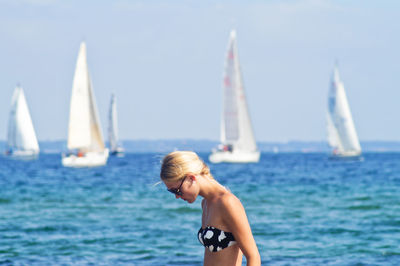 Woman wearing bikini top against sea