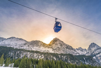 Low angle view of overhead cable car against sky