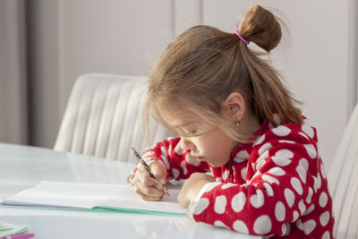 Girl sitting on table at home