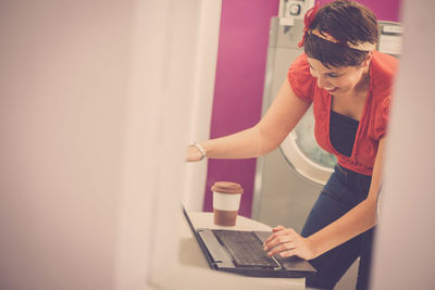 Cheerful woman using laptop at home