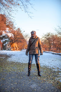 Portrait of woman standing on road during winter