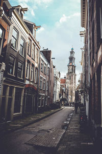 View of city street against cloudy sky