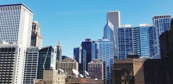 Low angle view of buildings against clear blue sky