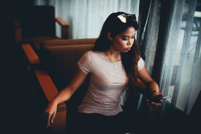 Young woman using mobile phone at cafe