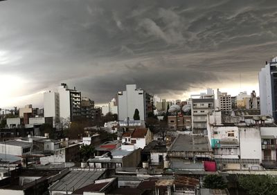 Skyscrapers in city against cloudy sky