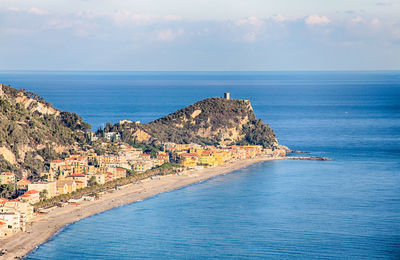 Scenic view of sea by buildings against sky