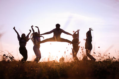 Group of people on field at sunset