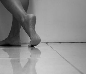 Low section of woman standing on tiled floor