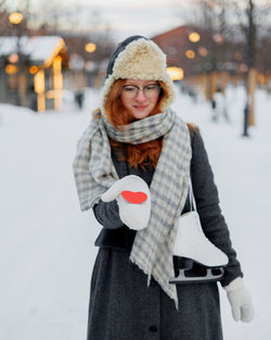 Portrait of smiling young woman standing in snow