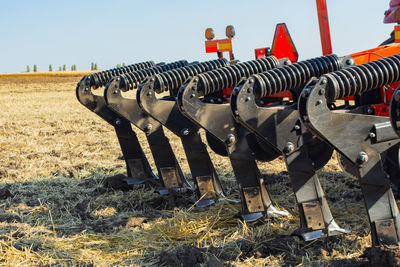 Row of metal structure on field against sky