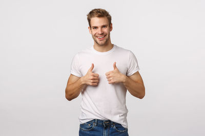 Portrait of smiling man standing against white background