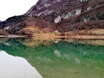 Scenic view of lake by mountain against sky