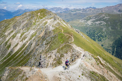 Rear view of man riding bicycle on mountain