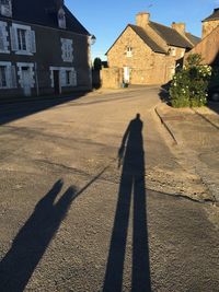 Shadow of people on street amidst buildings