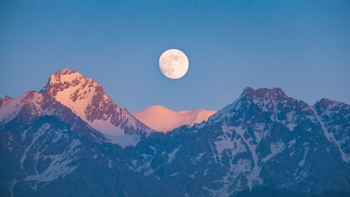 Scenic view of snowcapped mountains against blue sky