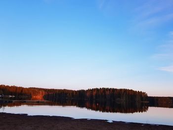 Scenic view of lake against clear blue sky during winter