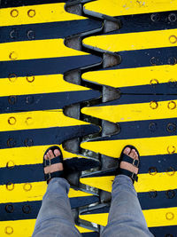 Low section of man standing on center line of down bridge