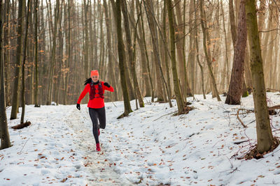 Rear view of woman walking on snow covered landscape