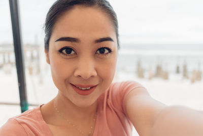 Close-up portrait of a smiling young woman selfie her self