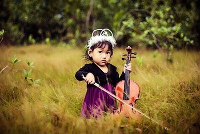 Girl playing violin on grassland
