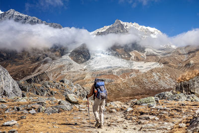 Rear view of hiker walking on mountain