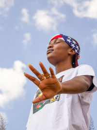 Side view of man with arms crossed against sky