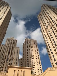 Low angle view of modern building against cloudy sky