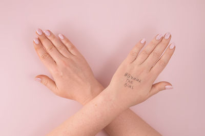 Cropped hands of woman against white background