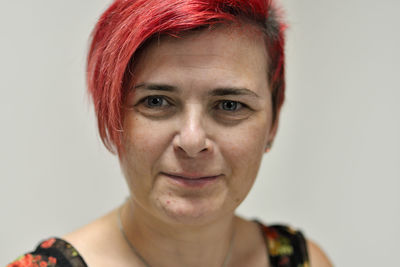 Close-up portrait of smiling young woman against white background